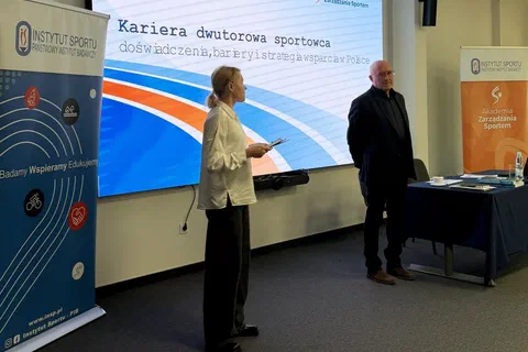 Dwoje prowadzących stojących przy ekranie z tytułem szkolenia o karierze dwutorowej sportowca.