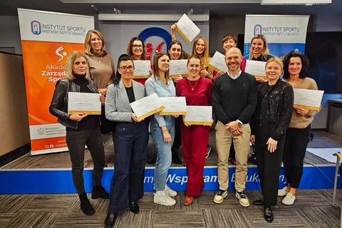 Grupowe zdjęcie uczestniczek prezentujących certyfikaty ukończenia cyklu szkoleń wraz z prowadzącym.