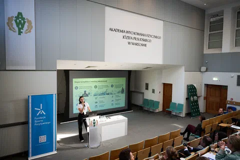 Prelegentka wygłaszająca referat z mównicy w auli wykładowej Akademii Wychowania Fizycznego w Warszawie.