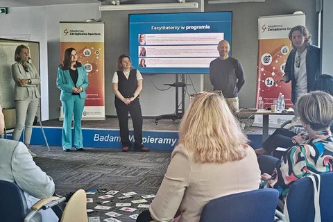 Prezentacja sylwetek facylitatorów programu na ekranie przed uczestniczkami siedzącymi w sali.