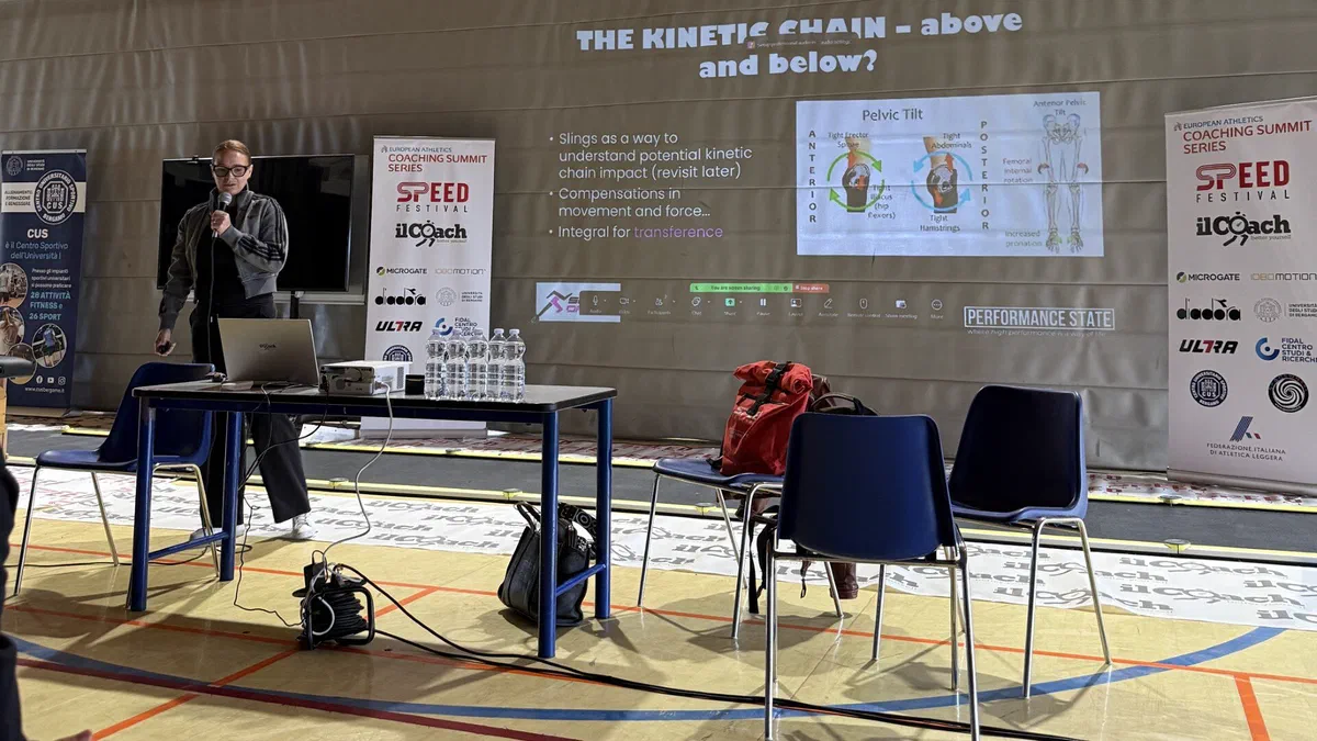 Prelegent występujący przed ekranem z prezentacją „The Kinetic Chain – above and below the hip” podczas konferencji SpeedFestival 2025.