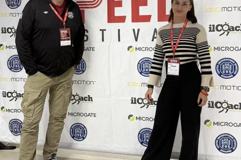 Dwoje uczestników konferencji z identyfikatorami stojących na tle ścianki SpeedFestival 2025.