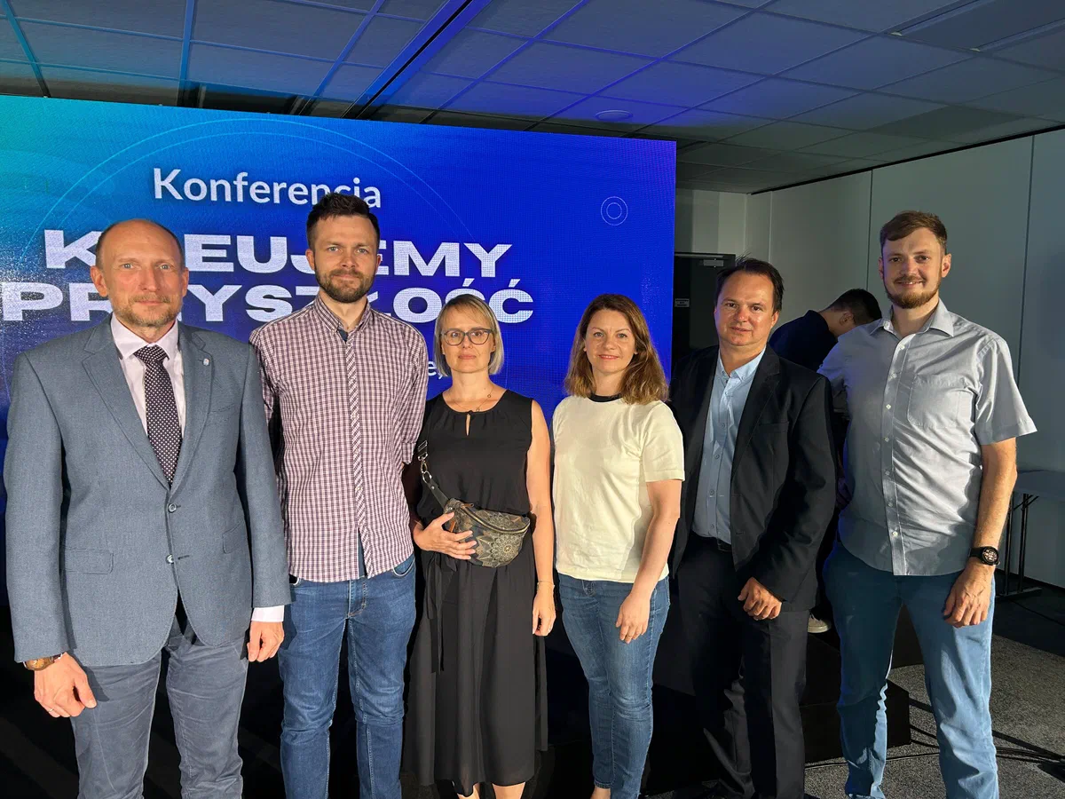 Sześcioro uczestników konferencji „Kreujemy przyszłość. Współpraca w Zintegrowanym Systemie Kwalifikacji” pozujących na tle ekranu konferencyjnego.