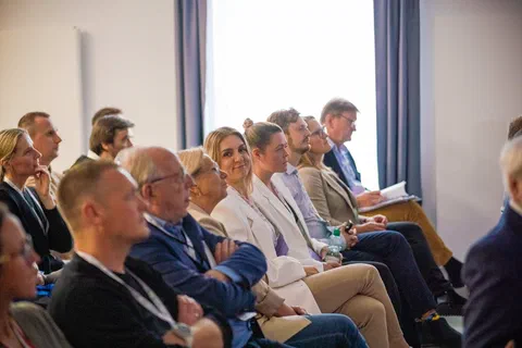 Uczestnicy konferencji siedzący w pierwszym rzędzie widowni.