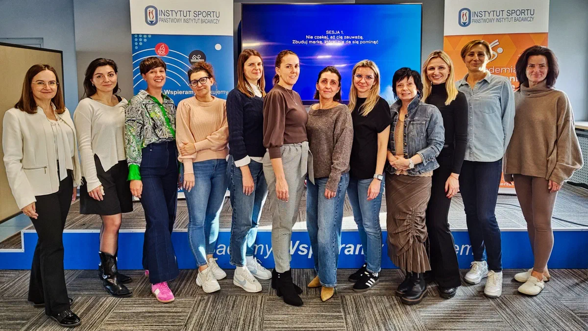 Grupowe zdjęcie uczestniczek szkolenia o marce osobistej liderki na tle ścianki Instytutu Sportu – PIB.