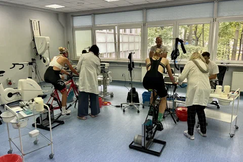 Zawodnicy wykonujący próbę wysiłkową na cykloergometrach pod nadzorem personelu w laboratorium