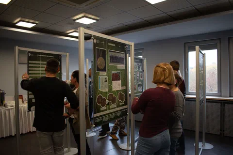 Zwiedzający oglądający ekspozycję planszową ustawioną na stelażach w sali Instytutu
